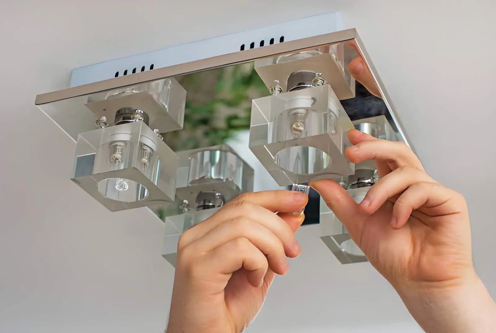 Electrician installing a modern ceiling light fixture